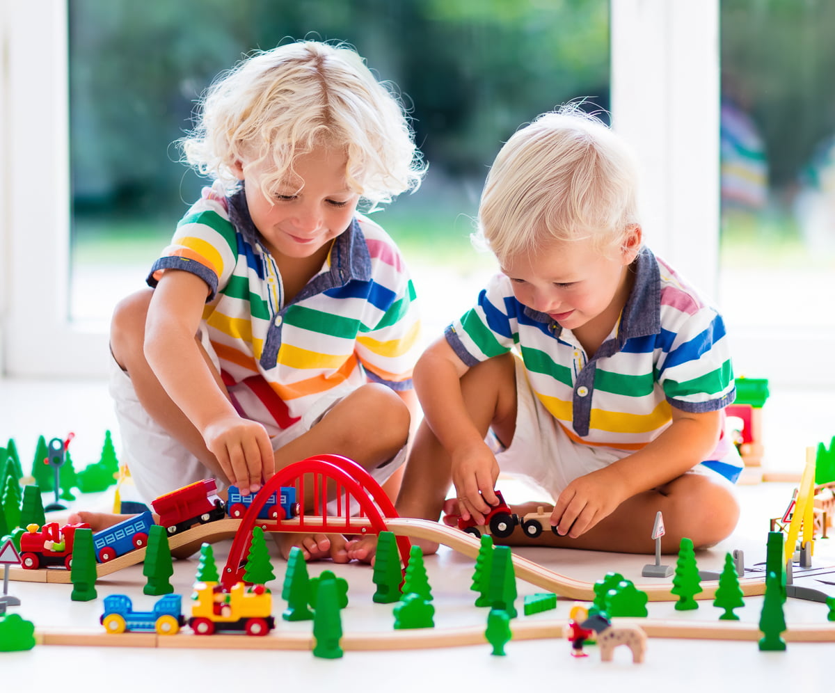 Two brothers playing with toy train